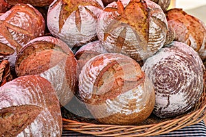 Big wicker basket ful of fresh baked homemade loafs of bread at the market for sale