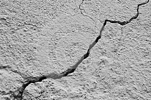 Big winding deep crack on old wall, abstract image of cleft with remnants of old plaster, abstract image of diagonal cleft.