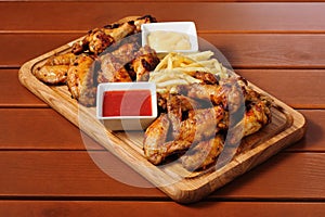 Big wooden board with grilled chicken winds