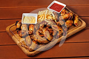 Big wooden board with grilled chicken winds