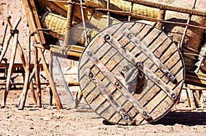 Big wooden wheel of a cart wagon with hay