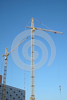 Big yellow construction tower crane on dwelling construction