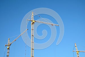 Big yellow construction tower crane over clear blue sky horizontal photo