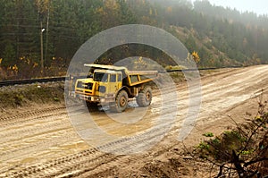 Earth mover loading dumper truck with sand in quarry. Excavator loading sand into dumper truck.Quarry for the extraction of minera photo