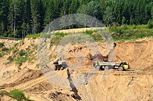 Big yellow dump truck transporting sand in an open-pit mining quarry