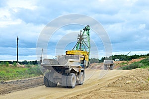 Big yellow dump truck working in the limestone open-pit. Loading and transportation of minerals in the dolomite mining quarry.