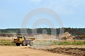 Big yellow dump trucks working in the open-pit.