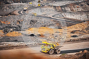 Big yellow mining truck transportation of gold ore. Open pit mine industry
