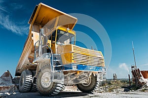 Big yellow mining truck vehicle, truck unloads mined ore or chalk or limestone. Mining industry concept