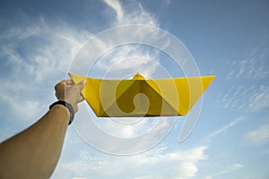 Big yellow paper boat with blue sky and white clouds