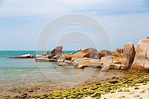 Big yellow rocks in the sea against the blue sky. Floating man in mask and flippers. Thailand. Samui. Gulf of Thailand. Lamai
