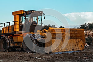 Big yellow tractor working on dirty ground