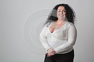 Big young woman in 30s wearing white shirt with cleavage