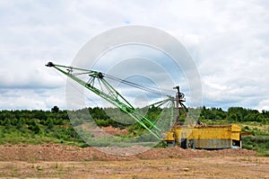 Biggest excavator dragline with a large bucket for the quarry overburden stripping.