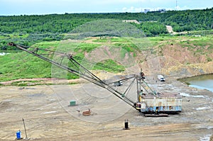 Biggest excavator dragline with a large bucket for the quarry overburden stripping.