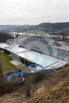 Biggest swimming complex with indoor and outdoor pools, toboggan water slide and diving towers with Vltava river in background