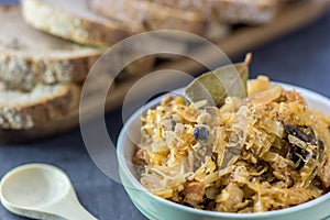 Bigos - traditional Polish dish - closeup in green bowl.