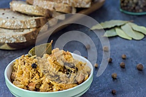 Bigos - traditional Polish dish - closeup in green bowl.