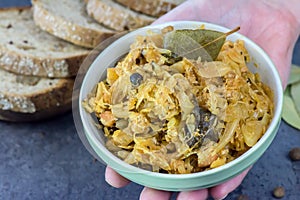 Bigos - traditional Polish dish - closeup in green bowl.