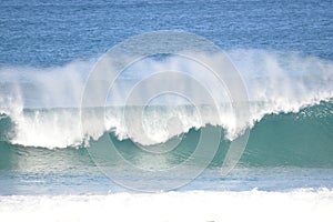 Big wind brings ocean spray to the crashing waves photo