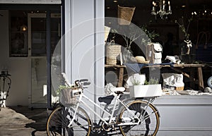 Bike with basket plants and decoration in front of the entrance of store. Vintage exterior look of an antique store