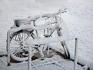 Bike at bike rack, snowed, covered in snow