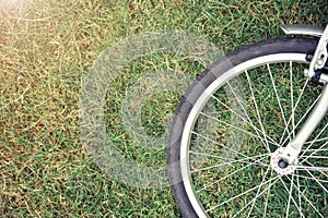 Bike concept background. Close up of bike wheel on green grass w