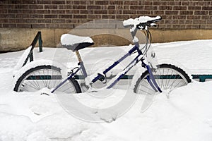 Bike covered in snow during snow storm