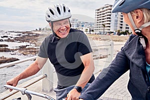 Bike, cycling and beach with a mature couple riding outdoor on the promenade during summer for exercise. Bicycle