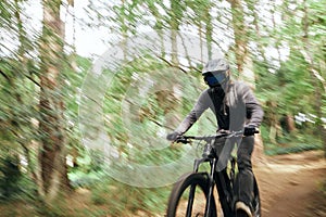 Bike, forest and man travel, fast and workout outdoor in woods for healthy body. Mountain bicycle, nature and athlete