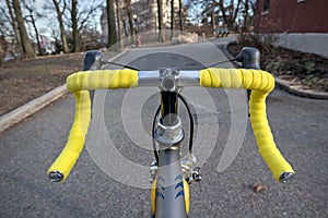 bike handlebar detail with bright yellow bar tape (bicycle cockpit, cycling) shifters, brifters, black quill stem