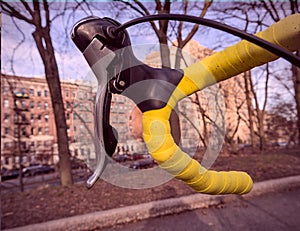 bike handlebar detail with bright yellow bar tape (bicycle cockpit, cycling) shifters, brifters, black quill stem