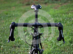 bike handlebars detail (front of bicycle with shifters, saddle, seatpost, cables and bar tape visible) outdoor cycling