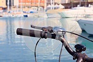 Bike with the handlebars out , parked in a port of Livorno , with many boats as background.