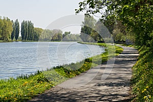 Bike lane bicycle cycle path by the river green trees EU supported project