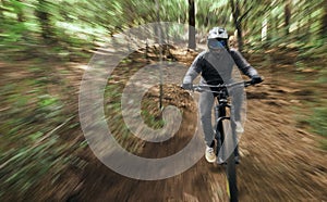 Bike, man in forest and speed blur in workout outdoor in woods for healthy body. Mountain bicycle, nature and fast