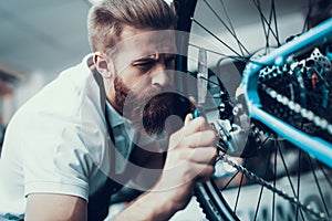 Bike Mechanic Repairs Bicycle in Workshop