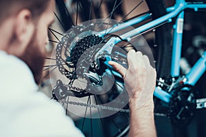 Bike Mechanic Repairs Bicycle in Workshop
