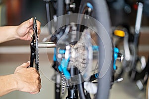 Bike mechanic repairs folding bicycle in Workshop. install Crankset Chainring,  Bicycle Maintenance and Repair concept