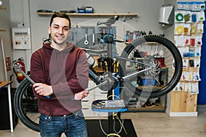 A bike mechanic standing in front of his bicycle at the bike shop