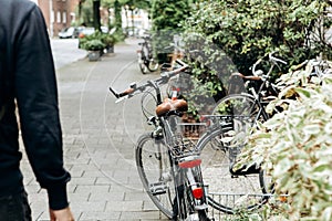 The bike is parked near the house on a beautiful street.