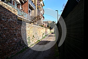 Bike path bordered by a brick wall in the italian countryside