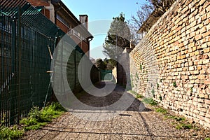 Bike path bordered by a brick wall in the italian countryside