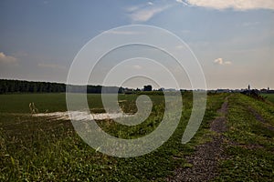 Bike path on an enbankment in the middle of the fields in the italian countryside in summer