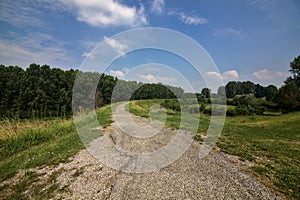 Bike path on an enbankment in the middle of the fields in the italian countryside in summer