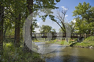 A bike path winding over a bridge in Fish Creek Provincial Park  Calgary Alberta Canada allows urban commuters a scenic route for