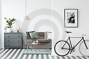 Bike and poster on the wall in a modern living room interior wit