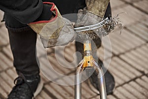 Bike renovation: man using a wire brush over a bike fork to remove the paint
