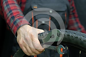 bike repair. Bike mechanic in the workshop. A mechanic holds tools and a bicycle wheel in his hand. Hands of the master and keys