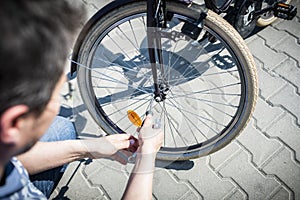 Bike repair. The man tightens the screw at the brakes with the key